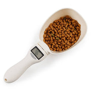 Digital pet food measuring spoon with electronic scale showing weight of cat and dog kibble in white scoop